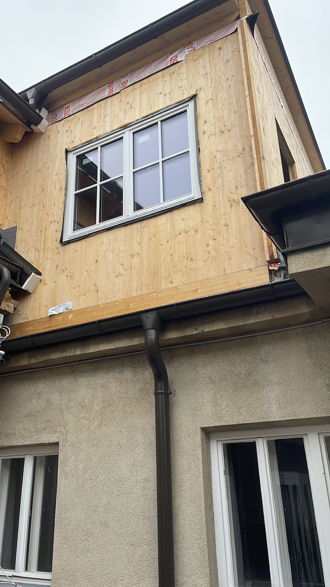 Neues Fenster mit moderner Wärmeschutz-Verglasung in einer Holzfassade